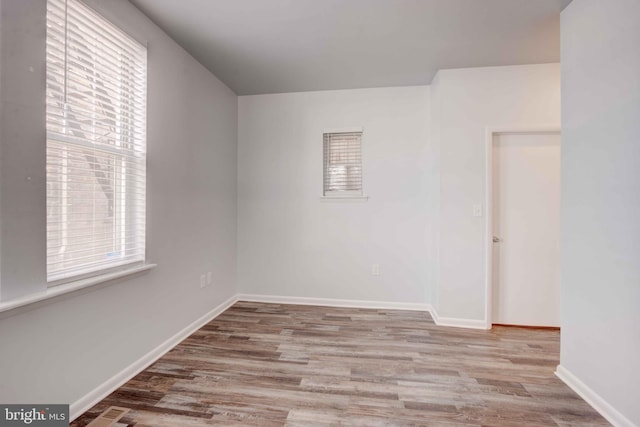 spare room featuring light wood-style floors and baseboards