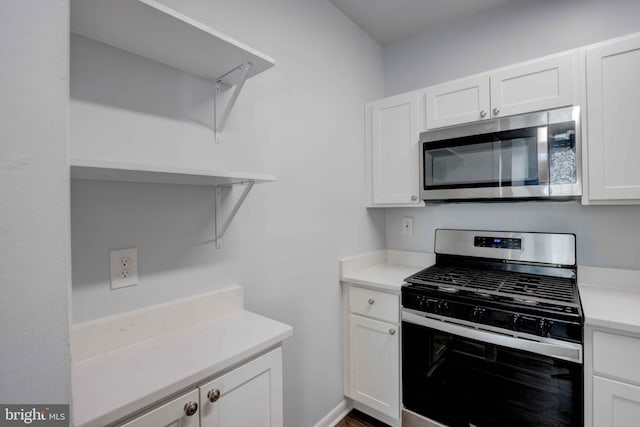 kitchen featuring stainless steel appliances, open shelves, light countertops, and white cabinets