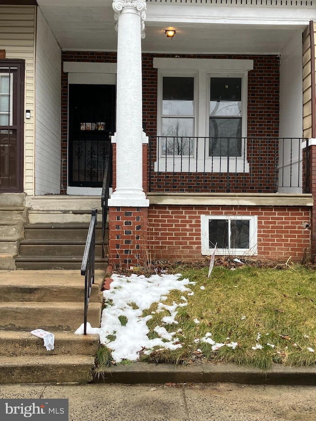 view of home's exterior featuring a porch and brick siding