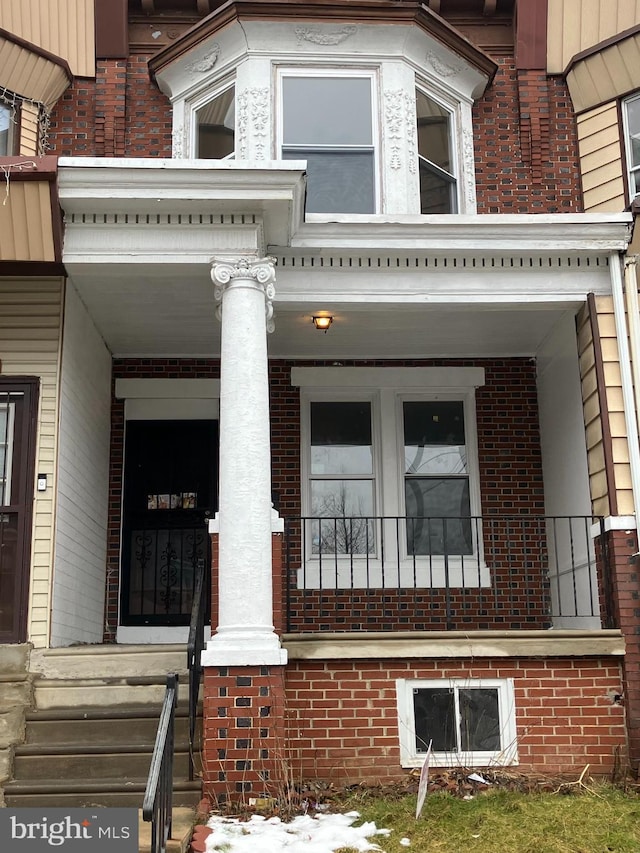 exterior space with brick siding and a porch