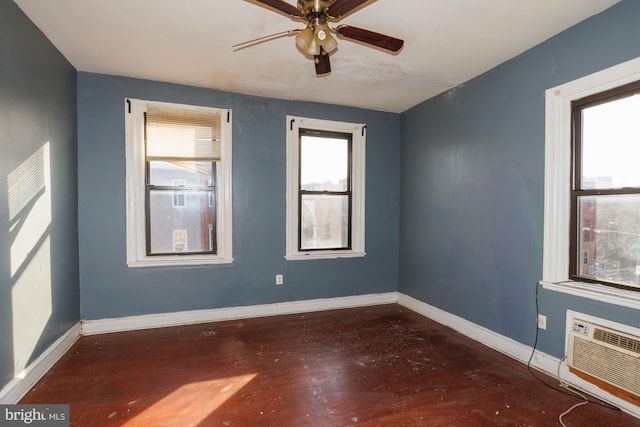 spare room featuring dark wood-style flooring, ceiling fan, baseboards, and a wall mounted AC