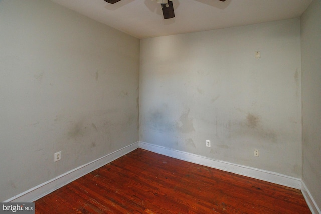 spare room featuring a ceiling fan, baseboards, and wood finished floors