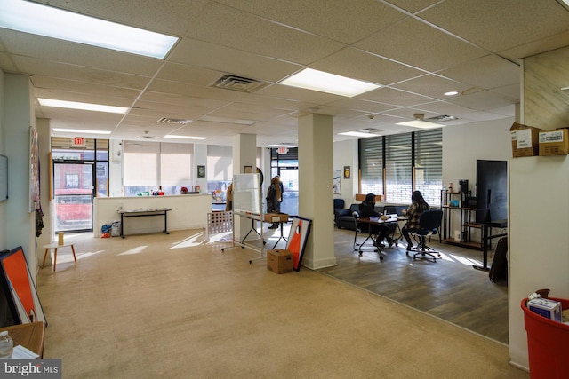 interior space with a paneled ceiling, visible vents, and wood finished floors