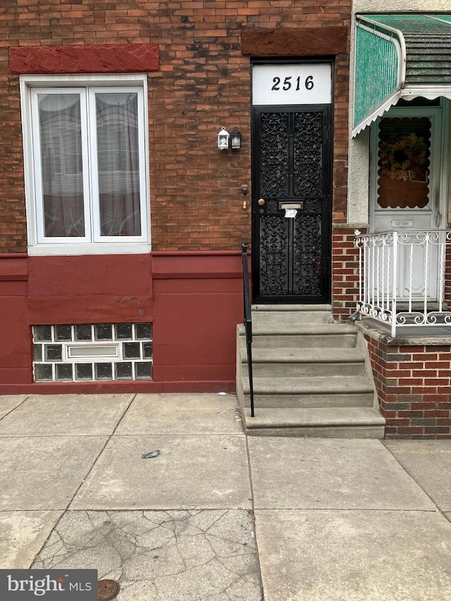 entrance to property featuring brick siding