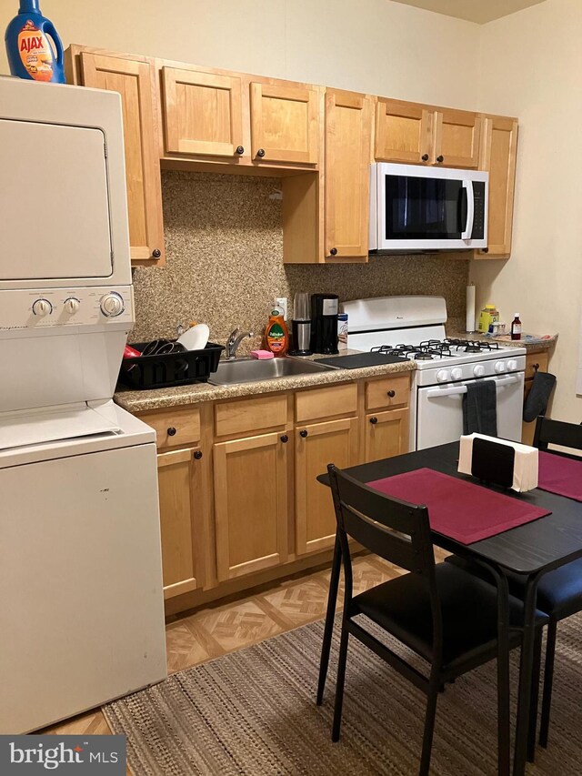 2516 S 6th St, Philadelphia, PA 19148 - kitchen featuring white appliances, tasteful backsplash, stacked washer and dryer, light brown cabinets, and a sink