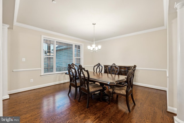 dining area featuring baseboards, ornamental molding, wood finished floors, a notable chandelier, and ornate columns