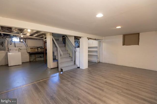 below grade area with washing machine and dryer, electric panel, stairway, and wood finished floors