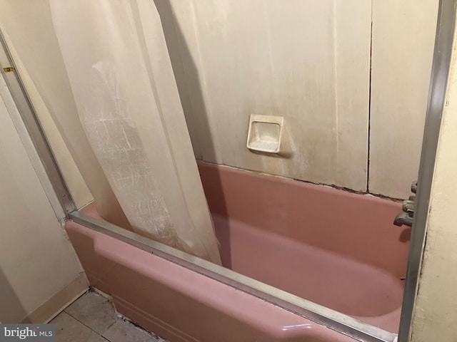 bathroom with shower / tub combo with curtain and tile patterned floors