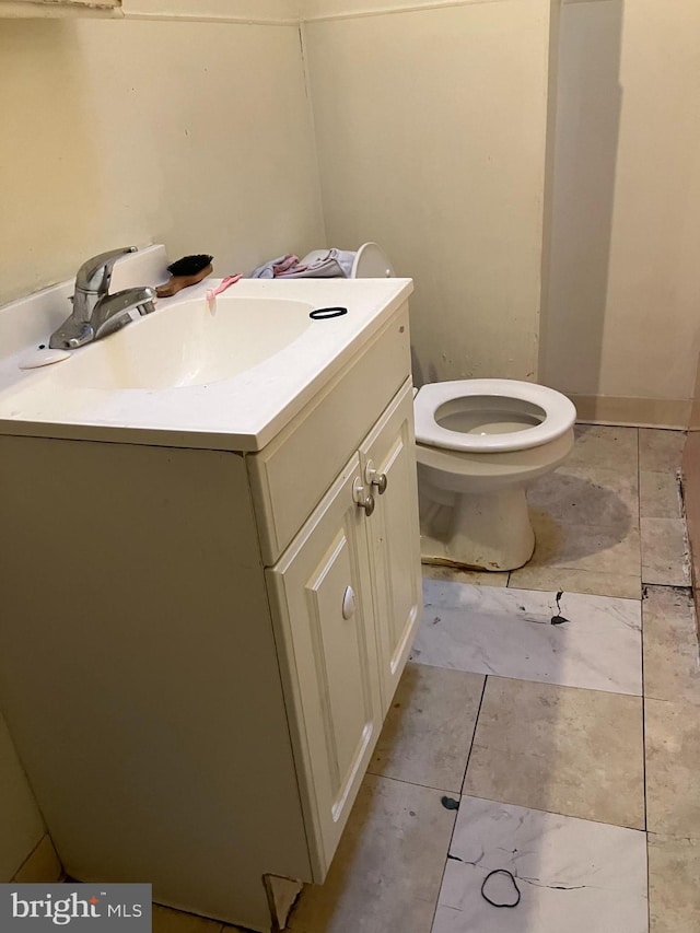 bathroom with toilet, vanity, and tile patterned floors