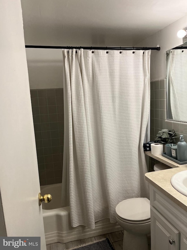 full bathroom featuring shower / tub combo with curtain, tile walls, toilet, vanity, and tile patterned flooring