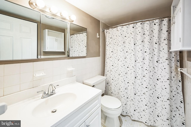 bathroom featuring toilet, a shower with shower curtain, tile walls, and vanity