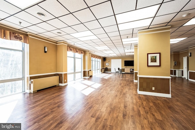 unfurnished living room with ornamental molding, visible vents, and wood finished floors