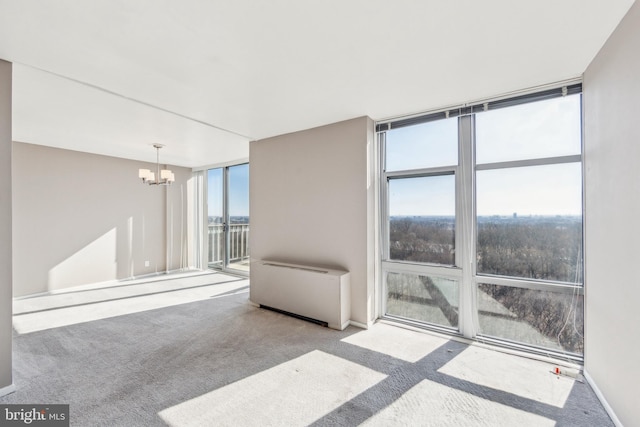 unfurnished room featuring baseboards, carpet floors, an inviting chandelier, and floor to ceiling windows