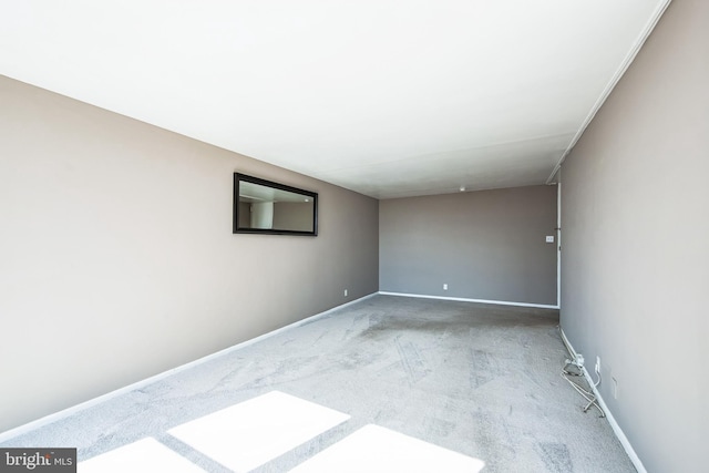 spare room featuring carpet floors and baseboards