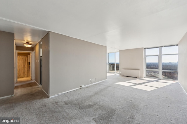 unfurnished room featuring carpet floors and baseboards