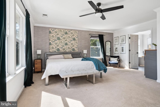 carpeted bedroom with baseboards, visible vents, a ceiling fan, and ornamental molding