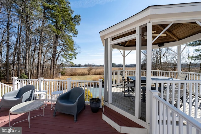 wooden deck featuring outdoor dining space and a gazebo