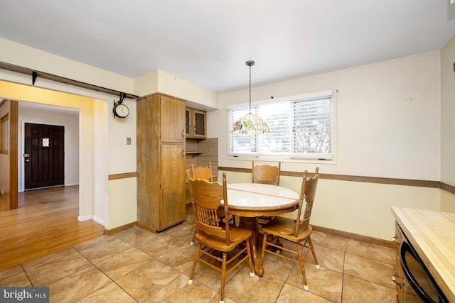 dining area with baseboards and light tile patterned floors