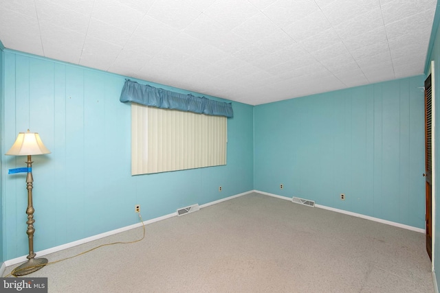 carpeted empty room featuring visible vents and baseboards