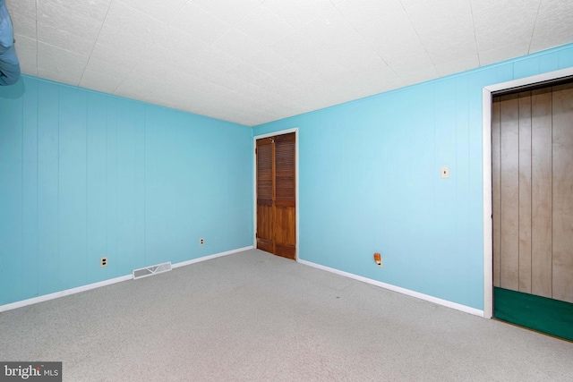 unfurnished bedroom featuring carpet floors, visible vents, and baseboards