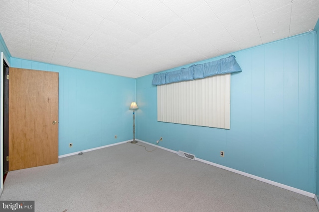 carpeted spare room with baseboards and visible vents