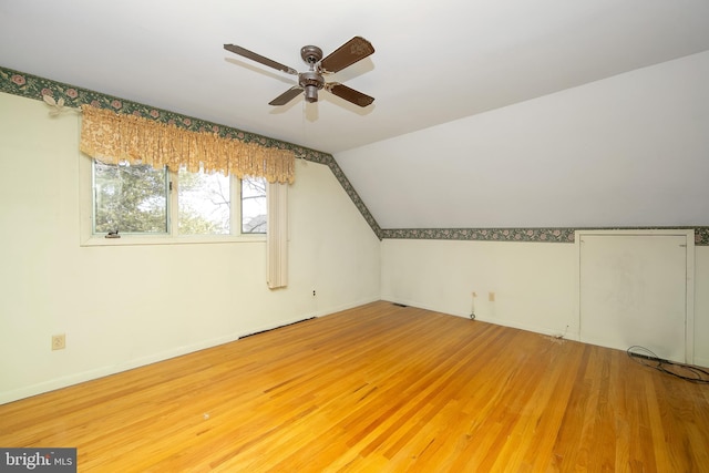 bonus room with lofted ceiling, ceiling fan, baseboards, and wood finished floors