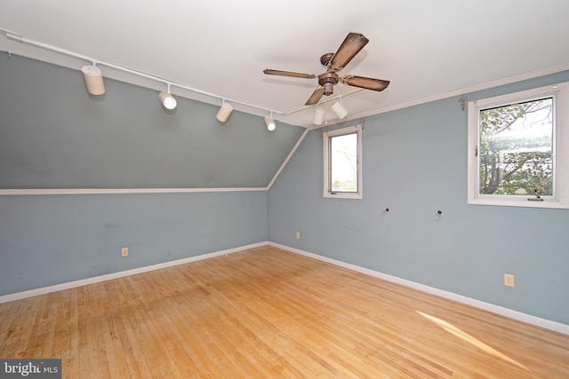 bonus room with lofted ceiling, wood finished floors, a ceiling fan, and baseboards