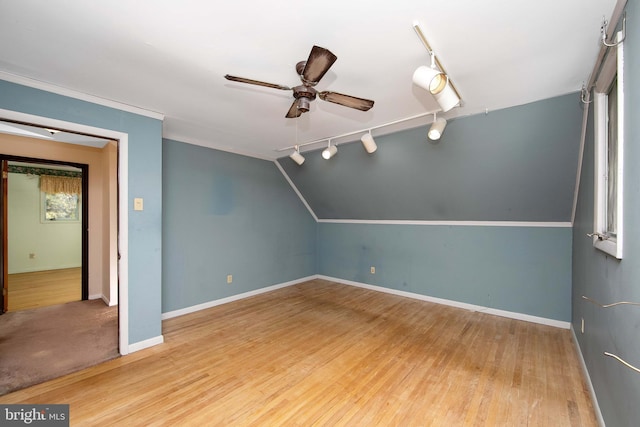 additional living space featuring a ceiling fan, baseboards, vaulted ceiling, and wood finished floors