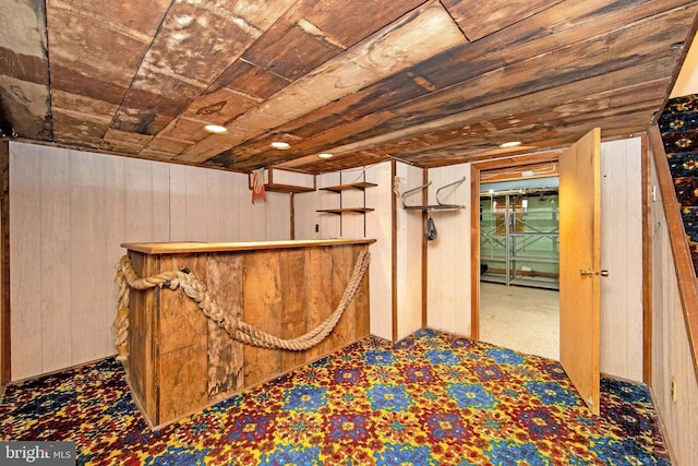 bar featuring wooden ceiling, wood walls, and a bar