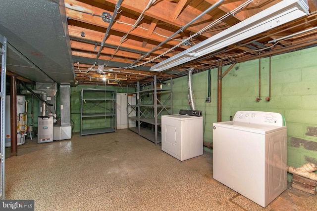 unfinished basement featuring washing machine and dryer, water heater, heating unit, and tile patterned floors