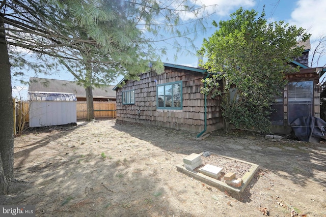 view of yard with fence and an outdoor structure