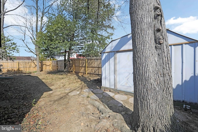 view of yard featuring a fenced backyard, a greenhouse, and an outbuilding