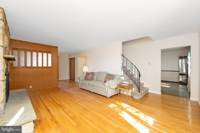 unfurnished living room featuring stairs, a fireplace, and wood finished floors