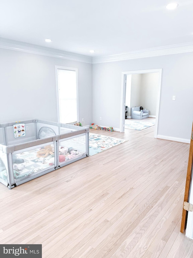 interior space featuring recessed lighting, crown molding, baseboards, and wood finished floors