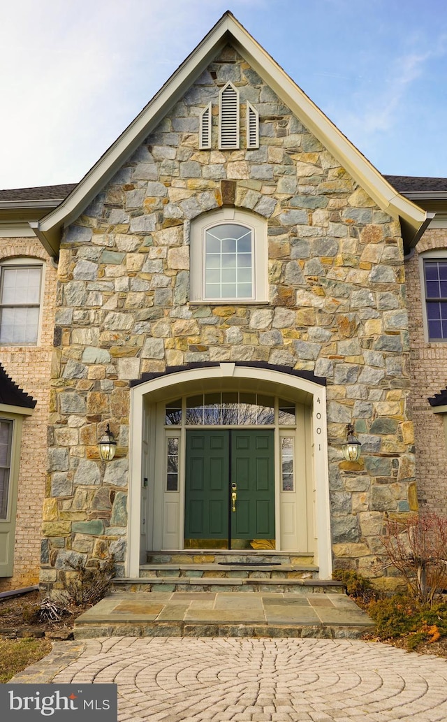 doorway to property with stone siding