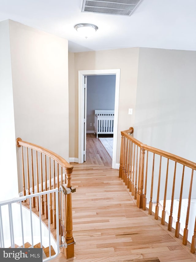 staircase with visible vents, baseboards, and wood finished floors