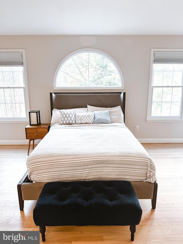 bedroom with baseboards and wood finished floors