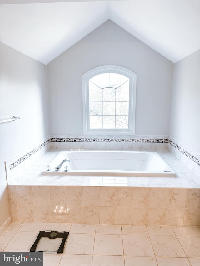 bathroom featuring lofted ceiling and a bath