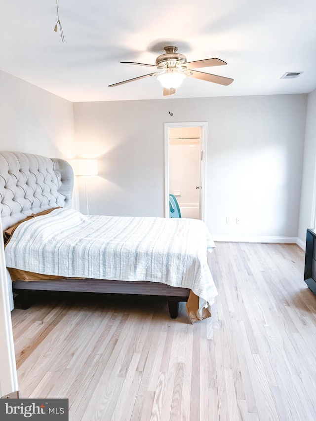 bedroom featuring baseboards, light wood finished floors, visible vents, and a ceiling fan