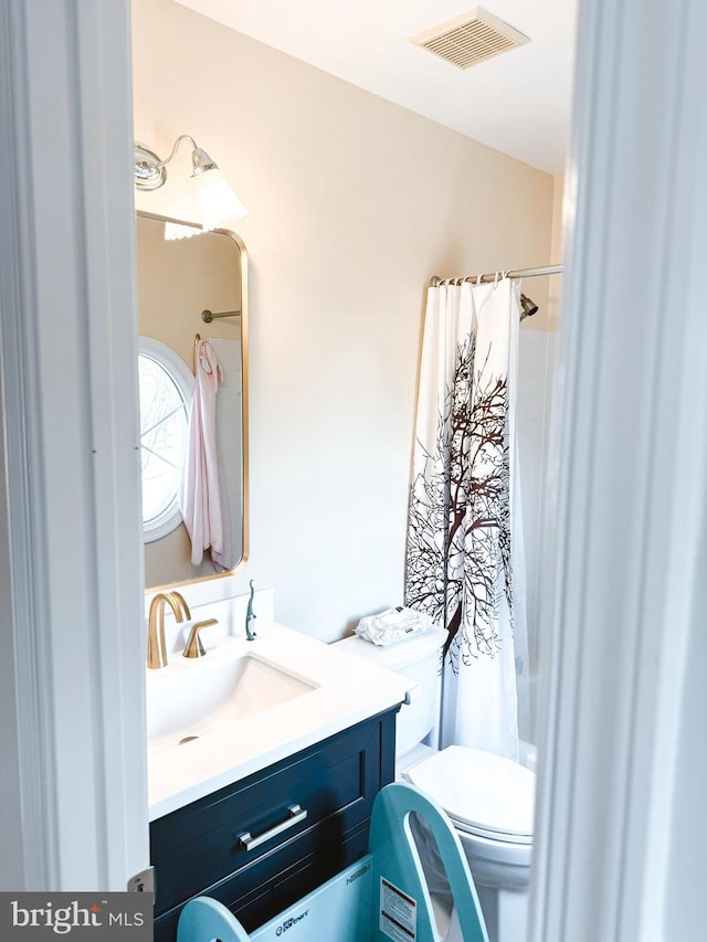 bathroom featuring visible vents, vanity, and toilet