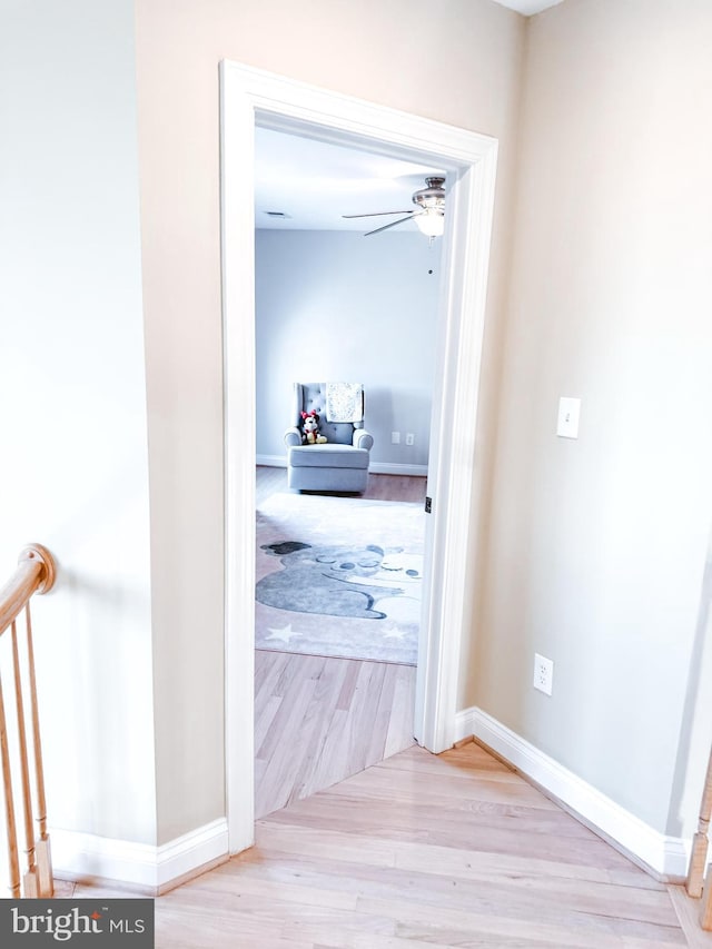 hallway featuring wood finished floors and baseboards