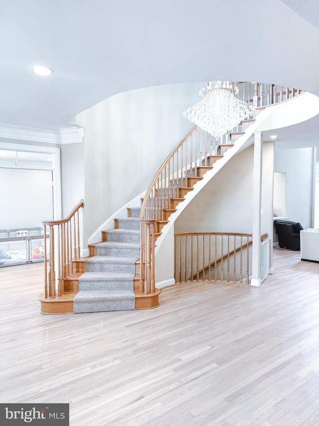 stairway featuring baseboards, wood finished floors, and ornamental molding