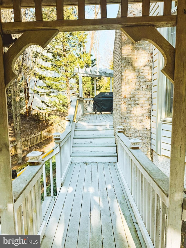 view of wooden balcony featuring a deck, grilling area, and a pergola