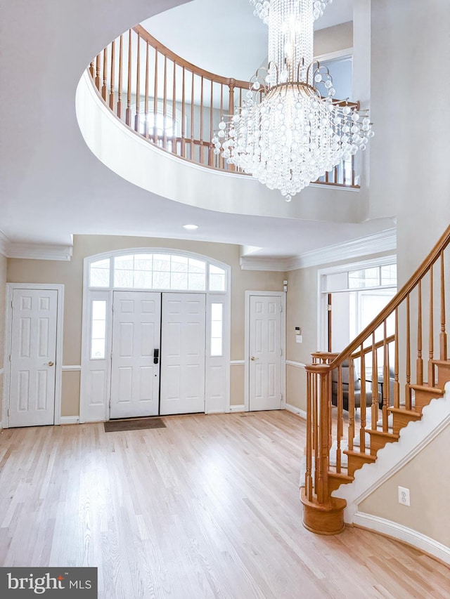 entryway featuring an inviting chandelier, a high ceiling, stairway, and wood finished floors