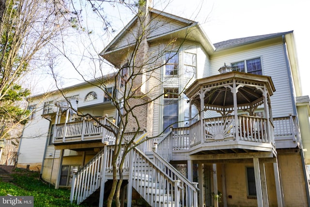 rear view of house with stairway and a deck