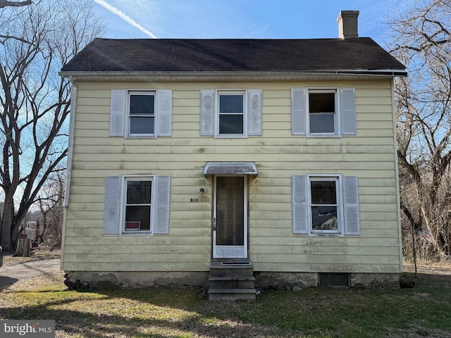 colonial home featuring entry steps and a chimney