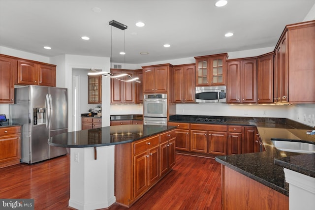 kitchen with recessed lighting, stainless steel appliances, a sink, dark wood-style floors, and glass insert cabinets