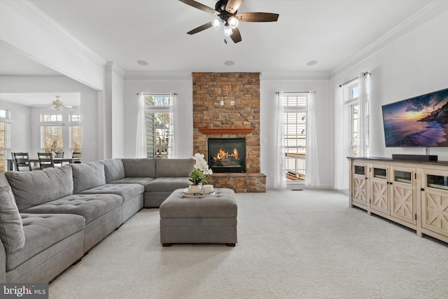 carpeted living room featuring a healthy amount of sunlight, a fireplace, and crown molding