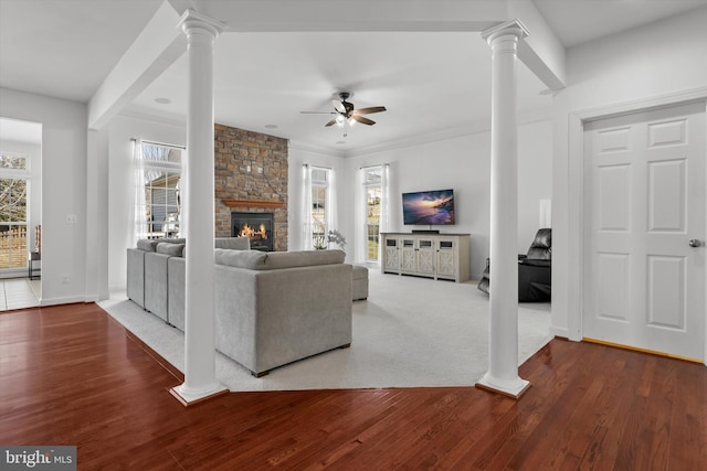 living area with wood finished floors and decorative columns