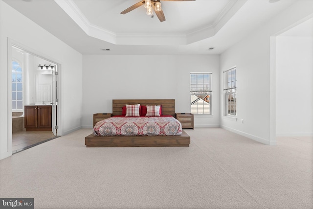 bedroom with ornamental molding, a tray ceiling, light carpet, and baseboards